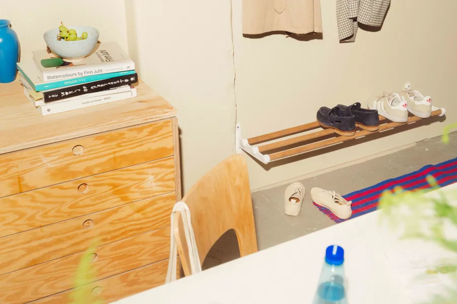 An industrial hallway with Nostalgi hat & shoe rack in marine bamboo and white used as a shoe rack